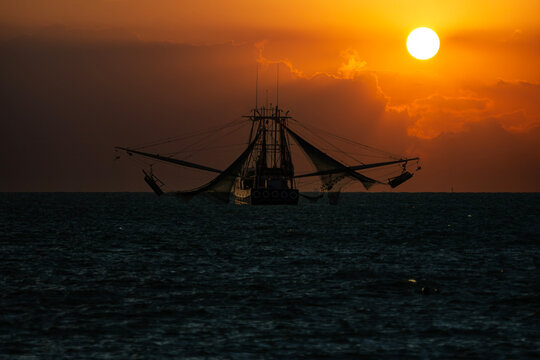 Golden Harvest: Silhouette of a Shrimp Boat at Sunset off the Coast of Key West
