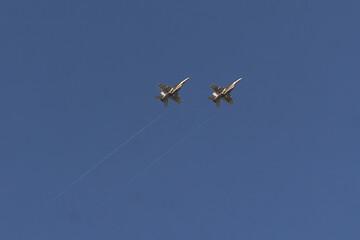 Fototapeta premium Naval Power: Underbelly Silhouette of a pair of F/A-18 Super Hornet over NAS Key West