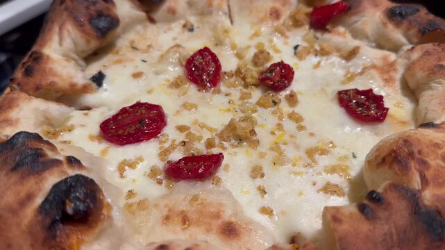 Delicious pizza with garlic, oil, chili pepper, dried tomatoes and a sprinkling of lemon zest