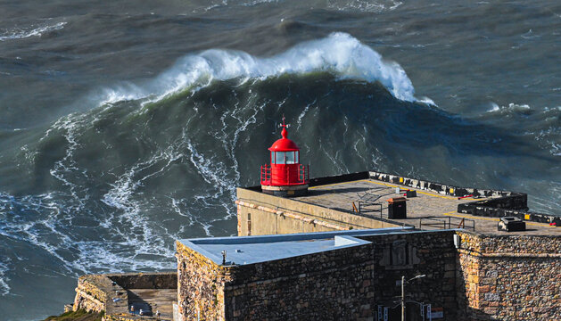 Giant Wave Crest Behind Nazare Lighthouse Portugal