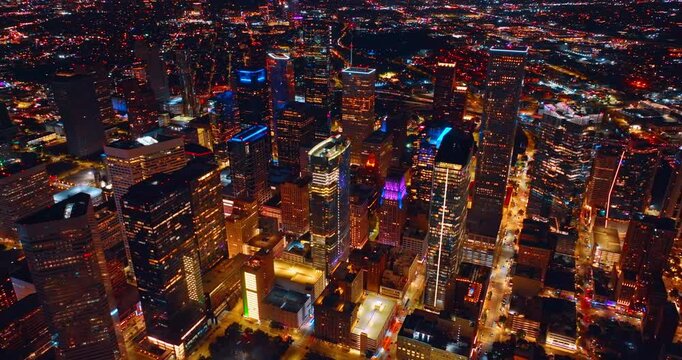 Beautifully lit cityscape of modern Houston, Texas, USA at night. Drone flight over the luminous streets and buildings of the city.
