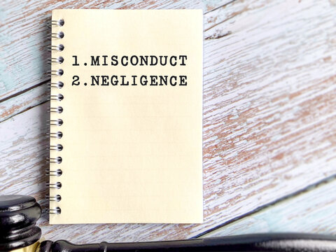Note book displaying misconduct and negligence terms representing workplace violation, legal responsibility, corporate ethics and employee discipline concept.