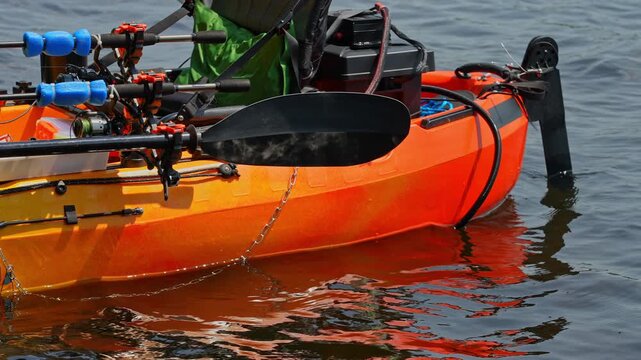 Fully rigged kayak watercraft mooring and tied to boat pier near cottage. Recreational watercraft, kayaking lake during tournament or fishing derby. Kayak water craft equipment for fishing activities.