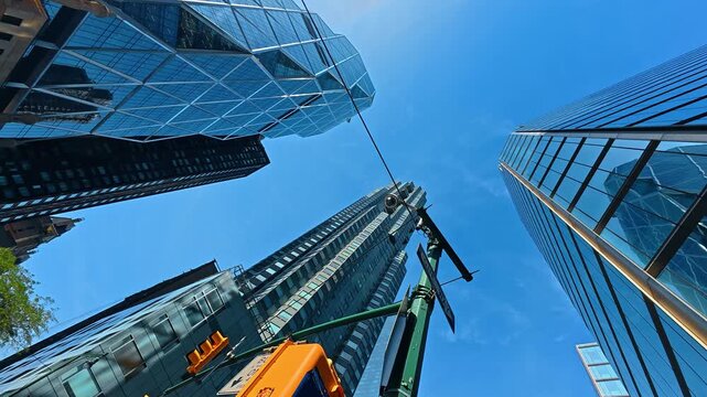 Standing on the 57 Street of New York at daytime. Low angle view at the glass skyscrapers against blue sky.