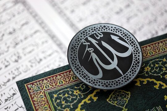 Sign with Islam inscription on Muslim holy book in mosque. Details of arabic calligraphy on sticker. Concept of Islam religion and praying in arabic countries