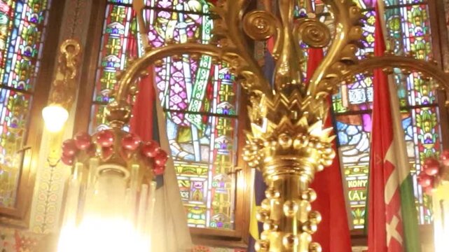 Cinematic pan left past glowing vintage lamp in historic synagogue interior