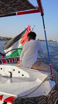 Man Relaxing on Traditional Felucca Sailboat During Sunset on the Nile River