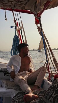 Tourist Experiencing Traditional Egyptian Felucca Boat Ride on the Nile