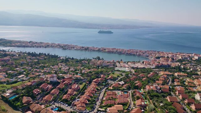 Cinematic aerial drone panorama of Ganzirri and Capo Peloro, Sicily. Stunning coastal landscape near Messina with the Lakes of Ganzirri and the narrow sea channel between Tyrrhenian and Ionian waters