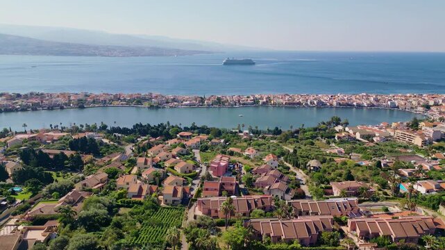 Cinematic aerial drone panorama of Ganzirri and Capo Peloro, Sicily. Stunning coastal landscape near Messina with the Lakes of Ganzirri and the narrow sea channel between Tyrrhenian and Ionian waters