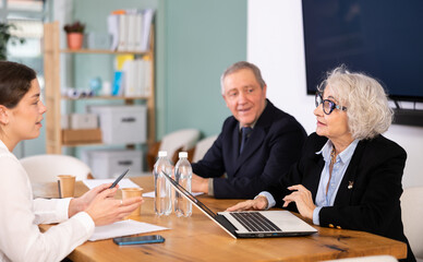 Obraz premium Senior representatives of business community participate at round table talks, chatting, talking. Brain storm, team discussion, debate, business coffee break, professional meeting