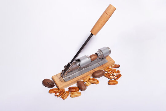 Pecan shelling machine with nuts around on a white background