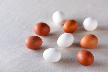 Brown and white chicken eggs on linen fabric, natural organic food background