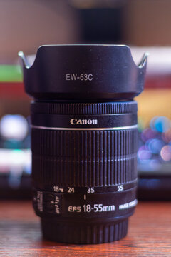 A Canon efs 18-55mm lens on wooden surface with blurred background for photography equipment concept