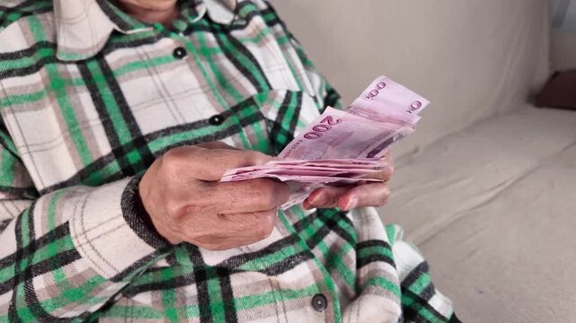 Close up of senior woman's hands counting Turkish lira banknotes