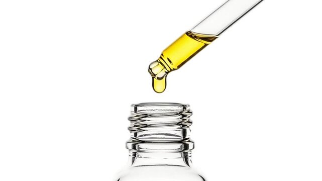 A dropper with yellow liquid over a clear glass bottle on an isolated white background