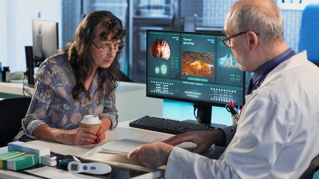 Medical expert examines a cancer screening scan with a patient, providing crucial prognosis information and treatment recommendations. Discusses a growing tumor detected via MRI. Camera A.