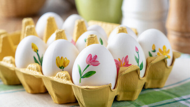 Decorative handmade Easter eggs in yellow carton, spring floral patterns, traditional holiday crafts, vibrant celebration, seasonal art, creative Easter concepts, springtime festivities
