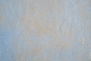 Fototapeta premium A horizontal close-up shot of a light blue painted metal surface covered with a dense pattern of tiny orange rust spots.