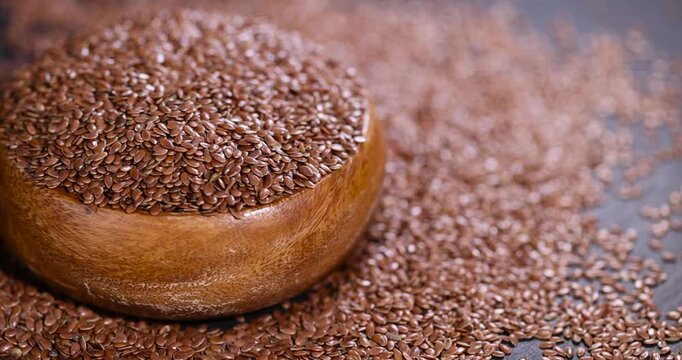 flax seeds poured into a wooden bowl, a round wooden bowl completely filled with flax seeds, which can be used both for nutrition and for obtaining a new crop