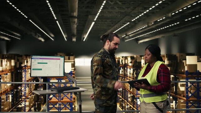 Military officer overseeing defense logistics within distribution center operations, monitoring cargo transportation and shipment tracking on pc. Soldier in uniform manages supply chain process.