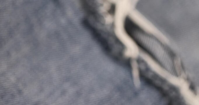 old torn jeans from long-term wear, part of blue jeans made of cotton fabric that are frayed and torn from long-term wear and use