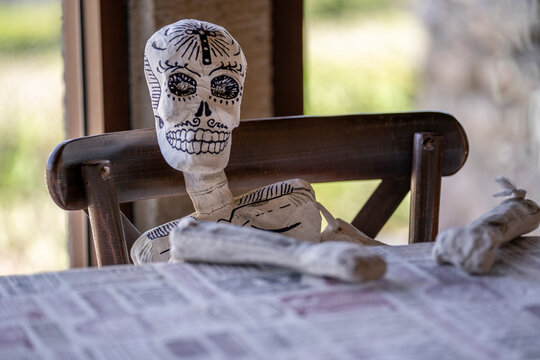 calavera tradicional de cartonaje decorada en blanco y negro sentada