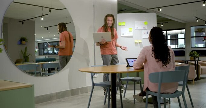 African American coworkers, standing man entering office with laptop, sticking notes for planning