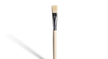 Fototapeta premium A single paintbrush with a beige handle and black ferrule stands upright on a white surface.