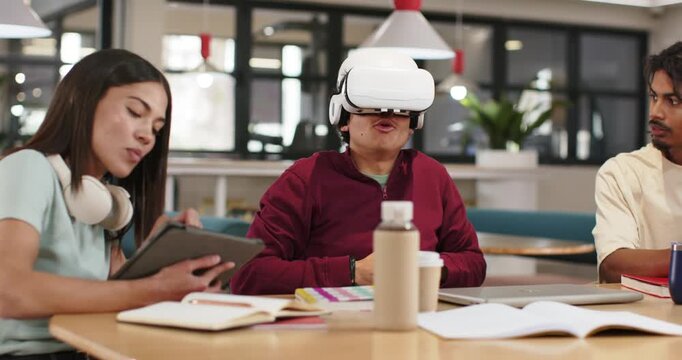 African American peers in lounge, tablet tapping starting white VR headset demo, VR user adjusting