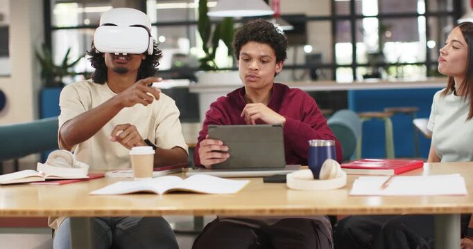 African American students wearing white VR headset pointing while tablet user guiding study at hub