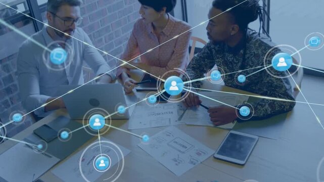Appearing network icon expanding over meeting table, driving team wearing shirts connecting devices