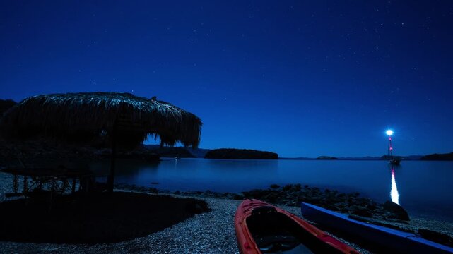Kayaks and sailboat ocean bay at night 