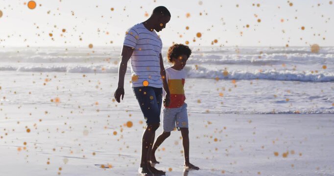 Walking dad and son bonding on beach in striped, color tees, camera panning, overlay rising