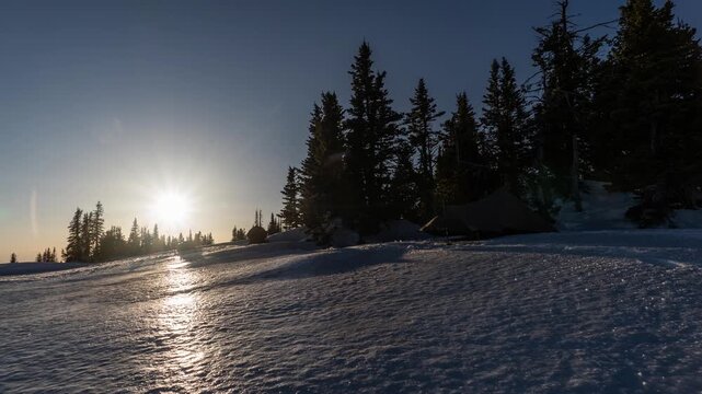 Setting up primitive base camp in winter in the mountains at sunset 
