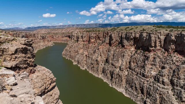 Cloud shadows moving over the Bighorn River winding through the deep cliffs of Bighorn Canyon on a sunny summer day, time lapse