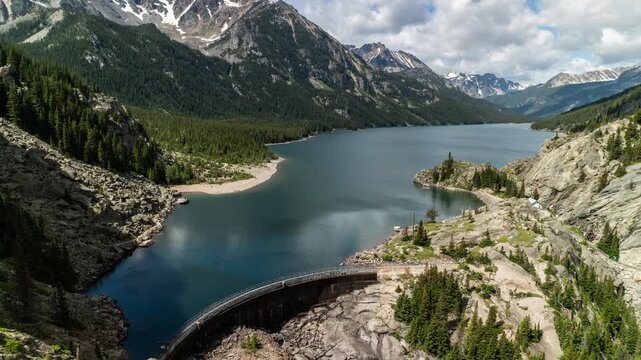Cloud shadows moving across Mystic Lake and its dam in a deep glacial valley surrounded by peaks, Beartooth Mountains, Montana, time lapse