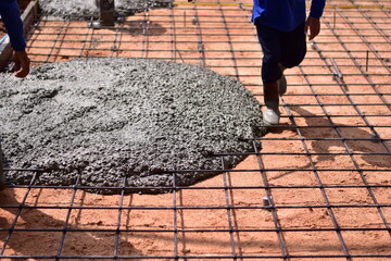 Pouring ready-mixed concrete onto reinforcing bars, We are pouring concrete on reinforced steel for...