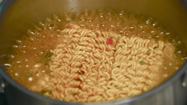 Vigorous boiling korean ramen in metal pot

