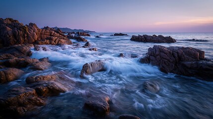 Serene Ocean Waves Crashing on Rocky Shore at Dusk.