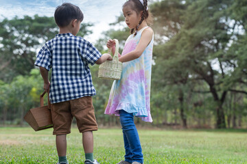 Fototapeta premium The boy and girl talked about the Easter eggs in the basket they had collected. Children and Easter.