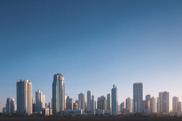City skyline landscape with modern skyscraper buildings under clear blue sky during daylight, showcasing urban architecture and cityscape in peaceful atmosphere
