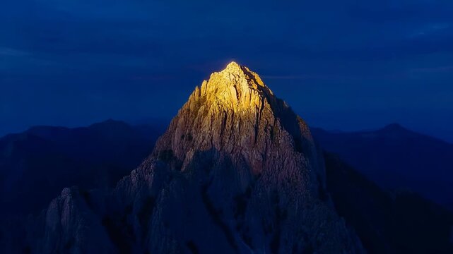 Abstract last sunbeam on highest peak background with golden summit against dark sky