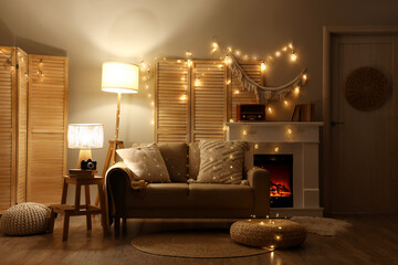 Naklejka premium Interior of dark living room with sofa, fireplace and glowing lights