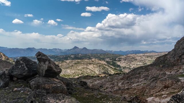 Cumulus clouds building over granite boulders and a rocky alpine basin with distant peaks, Beartooth Plateau, Montana, time lapse