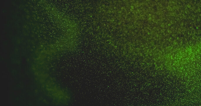 Defocused particles. Green light leak. Glimmer bright color glitter optical bokeh gleam vibrant twinkle on abstract art background.