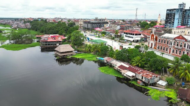 High-resolution aerial view of the riverfront boulevard in Iquitos featuring colorful historic buildings, vibrant urban streets, and a scenic promenade along the majestic Amazon River
