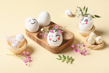 Wooden tray of cute painted Easter eggs with drawn face and flowers on yellow background