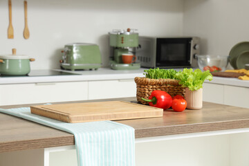 Fototapeta premium Cutting board with vegetables on table in kitchen
