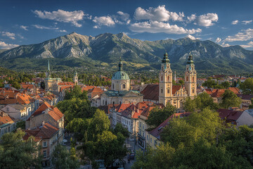 Fototapeta premium European cityscape with historic buildings and red rooftops under blue sky, set against backdrop of majestic mountains and lush greenery, creating peaceful and scenic atmosphere
